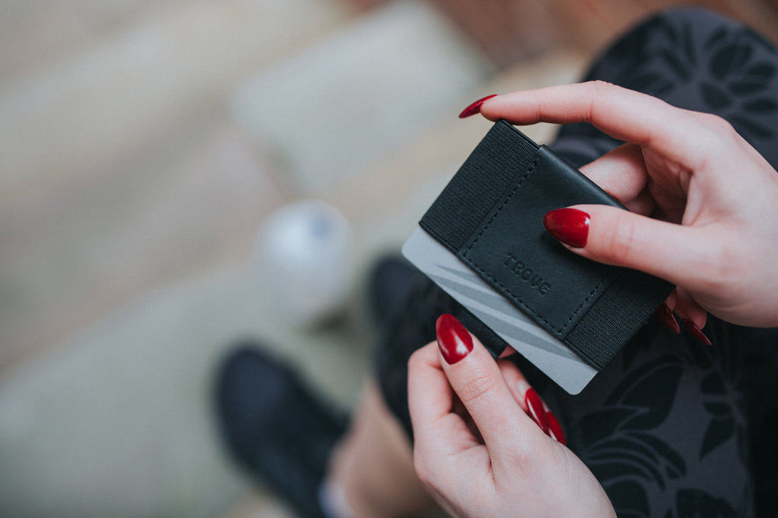 Hands holding a black TROVE Swift with a card partly withdrawn